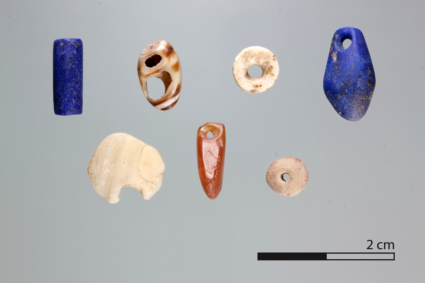 Perlen aus Karneol, Muschel und Lapislazuli aus äneolithischen Kontexten sowie aus Ton und anderen Steinarten aus neolithischen Kontexten.