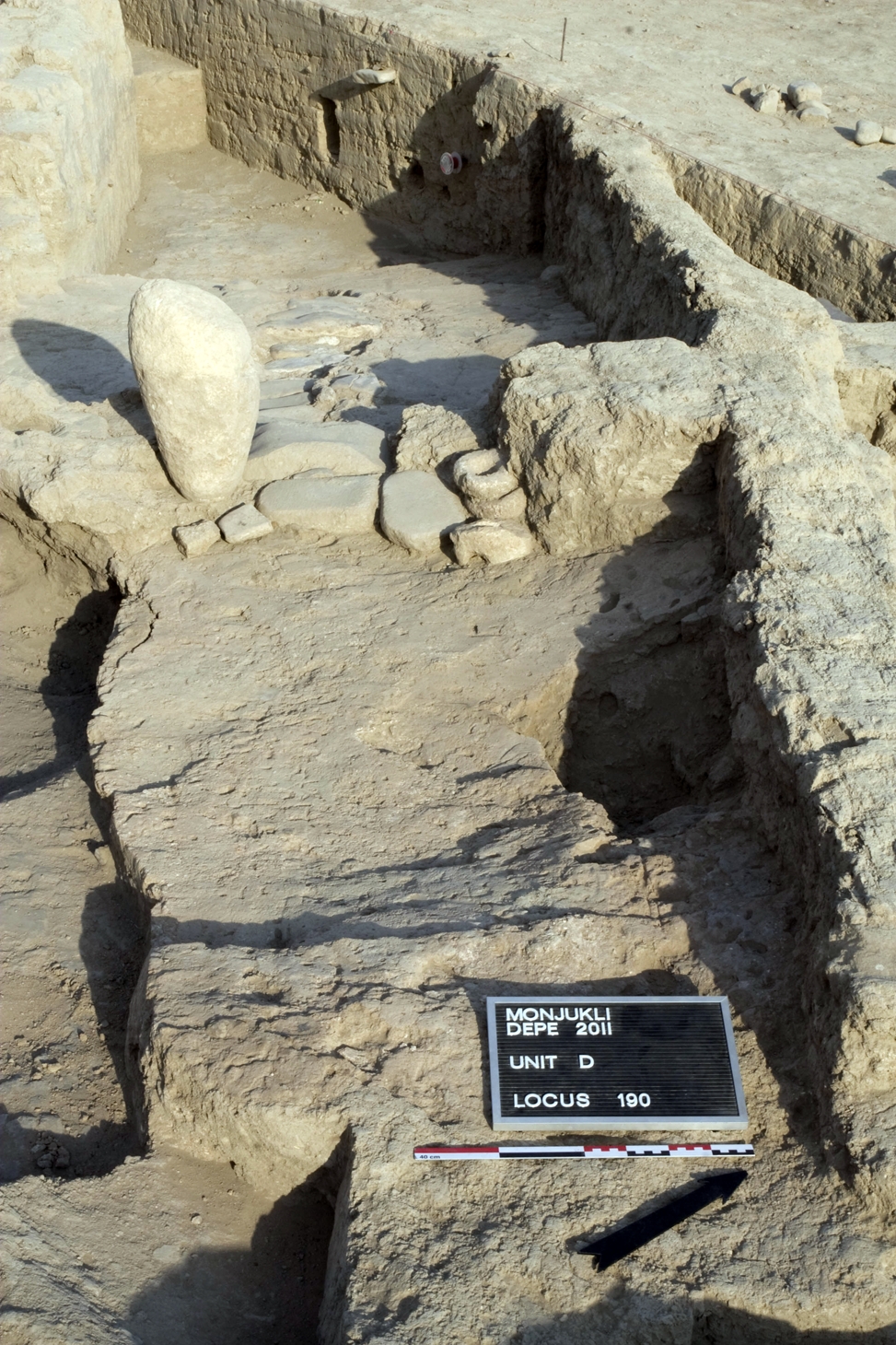 The area of Gate 1, at the end of Berdiev Street. The large, standing limestone boulder marks one side of the gate. An array of door sockets and grinding stones were placed at and around the threshold, pointing to its symbolic as well as functional importance.