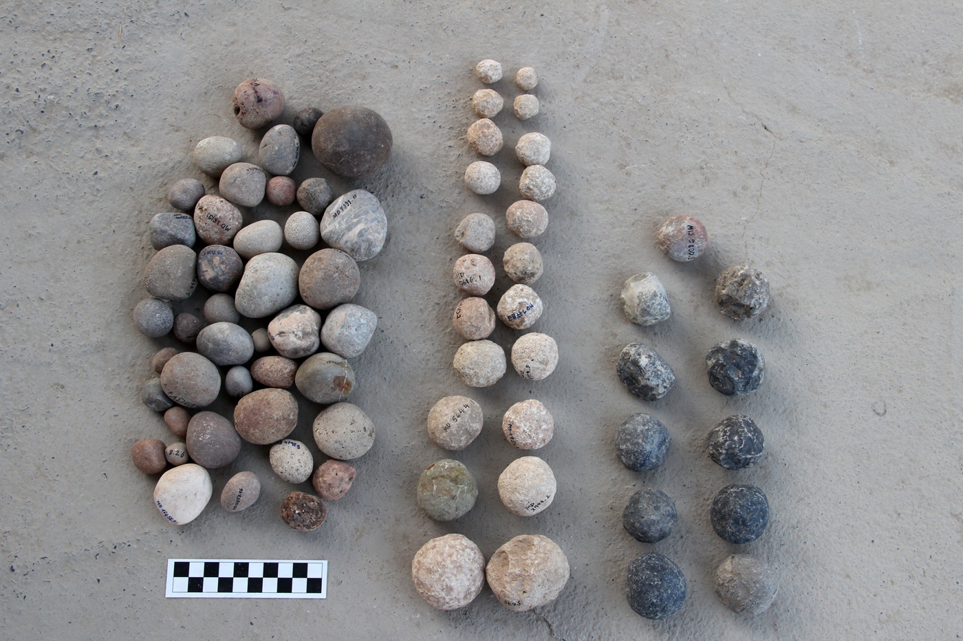 Stone balls (center and right), with naturally rounded stones (left) as a comparison.